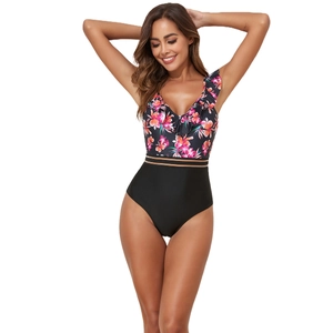 Detail view of floral print bodice with ruffle V-neckline and gold waist trim on swimwear