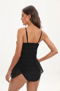 Détail d'un tankini noir avec résille géométrique ajourée et culotte de bikini taille haute