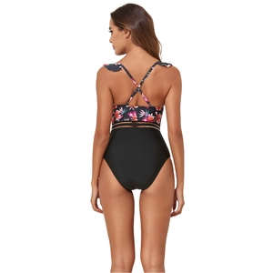 Detail of cross-back straps and tropical floral print on one-piece swimsuit with mesh