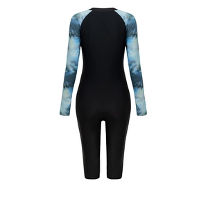 Rear view of long sleeve one-piece swimsuit with blue wave print and mid-length legs