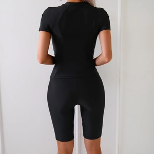 Rear view of black two-piece sporty swimsuit with short sleeve top and high-waisted shorts