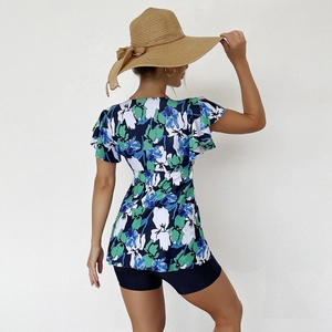 Detail of floral tankini top with ruffled sleeves and dark blue swim shorts set