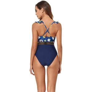Detail of cross-back straps and floral print on a one-piece swimsuit with mesh panel