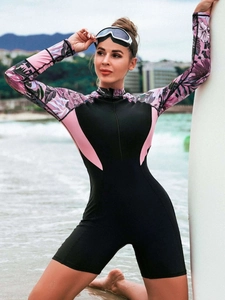 Dettaglio del costume da bagno floreale a maniche lunghe con zip frontale e inserti rosa