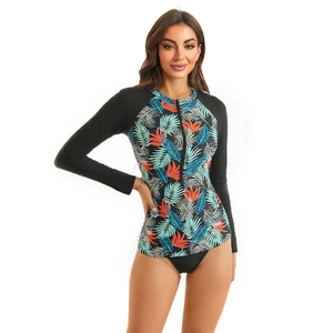 Close-up of long sleeve rash guard featuring tropical leaf print and front zipper closure
