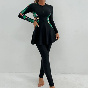 Front zipper detail of modest long sleeve swimwear with tropical leaf print and black fabric