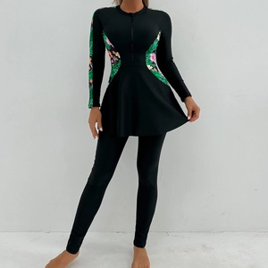 Detail of modest long-sleeved swimwear featuring tropical leaf prints and a front zipper