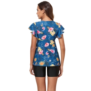 Rear view of floral ruffle top and black swim shorts showing a flattering back coverage