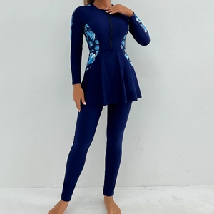 Detail of modest burkini swimwear with long sleeves and blue tropical leaf print