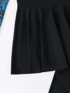 Détail d'une jupe de bain plissée noire avec manche à imprimé tropical bleu de qualité