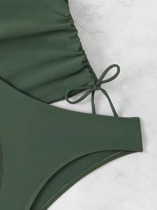 Close-up of forest green swimsuit with side drawstring detail and pleated texture