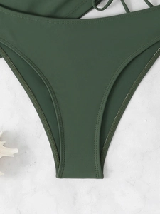 Detailed macro view of dark green high-waist bikini bottoms with premium double-stitch seams