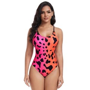 Detailed front view of one-piece swimsuit with pink orange gradient and black cow pattern