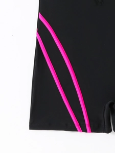 Detail of neon pink piping and stitching on black athletic swimwear fabric