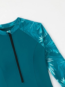 Détail d'un maillot de bain à manches longues sarcelle avec imprimé tropical et zip