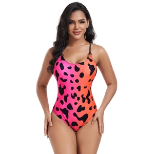 Detail of pink-orange gradient one-piece swimsuit with black cow spots and metal rings