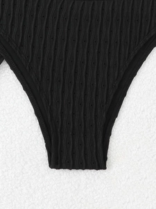 Detailed macro view of black wavy textured fabric with eyelet holes for bikini bottom