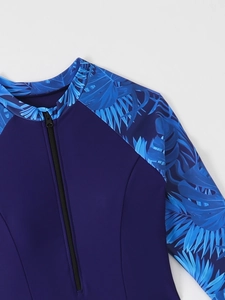 Détail de la fermeture éclair avant et de l'encolure sur un rash guard violet tropical