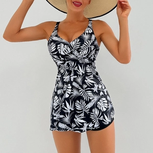 Detail of V-neck ruffled bodice on black swimsuit with white tropical palm leaf print