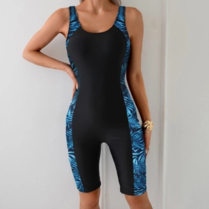 One-piece athletic swimsuit with blue tropical print and black panels featuring mid-thigh legs