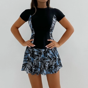 Détail d'un maillot de bain tankini à manches courtes avec imprimé palmier et jupe plissée