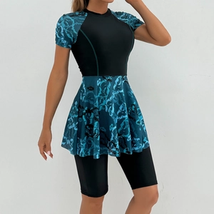 Detail of short sleeve one-piece swim dress with teal snake print cuffs and hemline