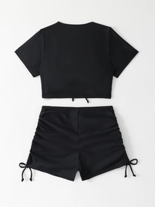 Detail of two-piece black swimsuit featuring drawstring cropped top and high-waisted shorts