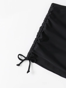Detail view of the black bikini bottom side ties and soft matte fabric texture