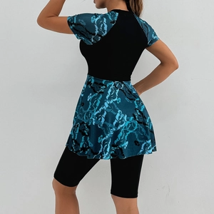 Detail view of the short sleeves and flared skirt hem with teal abstract pattern