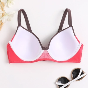 Detailed flat lay of pink and taupe contrast bikini top with floral and sunglasses decor