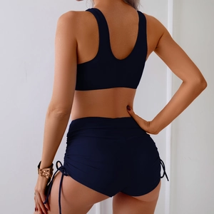 Rear view of navy blue two-piece bikini with side drawstring shorts and athletic top