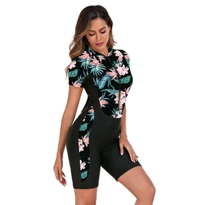 Detail of a short sleeve one-piece swimsuit with tropical floral print and front zipper