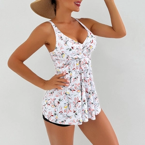 Detail of V-neck floral swim dress with ruched waist and white botanical print pattern