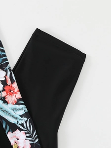 Close-up of tropical floral print and black matte fabric on two-piece swimwear