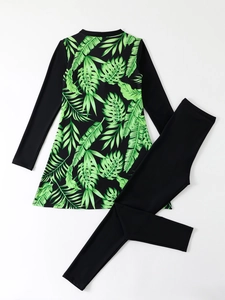 Detail of two-piece long sleeve swimsuit with tropical green leaf print and black leggings