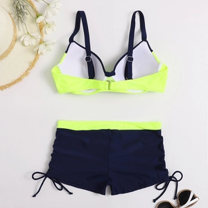 Flat lay of a two-piece bikini set with neon yellow contrast and side drawstring detail