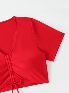 Detail of red V-neck bikini top featuring drawstring ruched front and fine stitching
