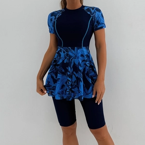 Detail of short sleeve modest swim dress with tropical leaf print and navy swim shorts