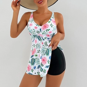 Detail of floral print tankini top with twist front design and black swim shorts