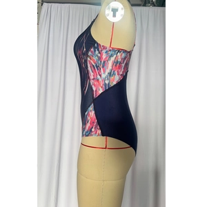 Detail of navy one-piece swimsuit featuring side geometric prints and high-cut leg design