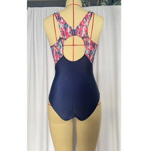 Macro detail of the racerback cut and circular cutout on this athletic one-piece swimsuit