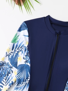 Close-up of long sleeve swimwear featuring a front zipper and tropical floral patterns