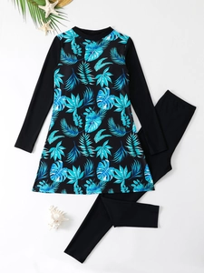 Flat lay view of long-sleeve two-piece swimsuit with tropical leaf print on white background