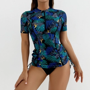 Détail du haut de bikini de surf à manches courtes avec imprimé tropical et zip frontal