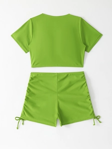 Flat lay back view of a neon green short sleeve crop top and drawstring bikini shorts