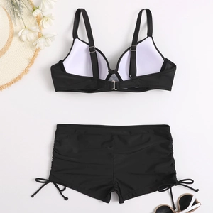 Detailed flat lay of black two-piece bikini with adjustable straps and drawstring shorts