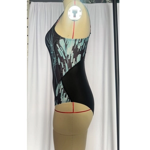 Side view detail of a black one-piece swimsuit with blue and white geometric side patterns