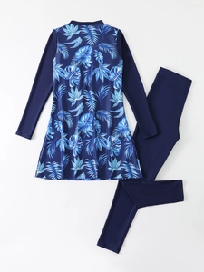 Detailed flat lay of long sleeve burkini swimwear with tropical leaf print and blue pants