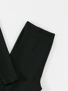 Close-up of flatlock stitching on black high-stretch fabric of long sleeve swimsuit pants