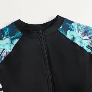 Détail du tissu noir élastique avec imprimé floral tropical et fermeture éclair frontale